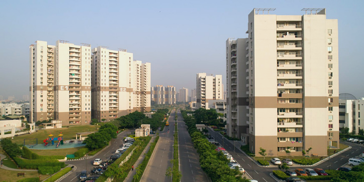 vatika gurgaon 21 three high rise towers with a road in between with green landscapes around