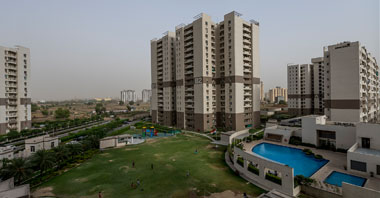 a view of landscaped garden & buildings of gurgaon 21 in vatika inxt a project by vatika group