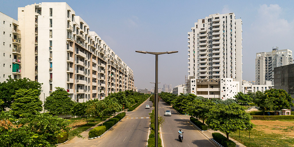 cars driving on the road alongside independent builder floors in vatika india next by vatika group