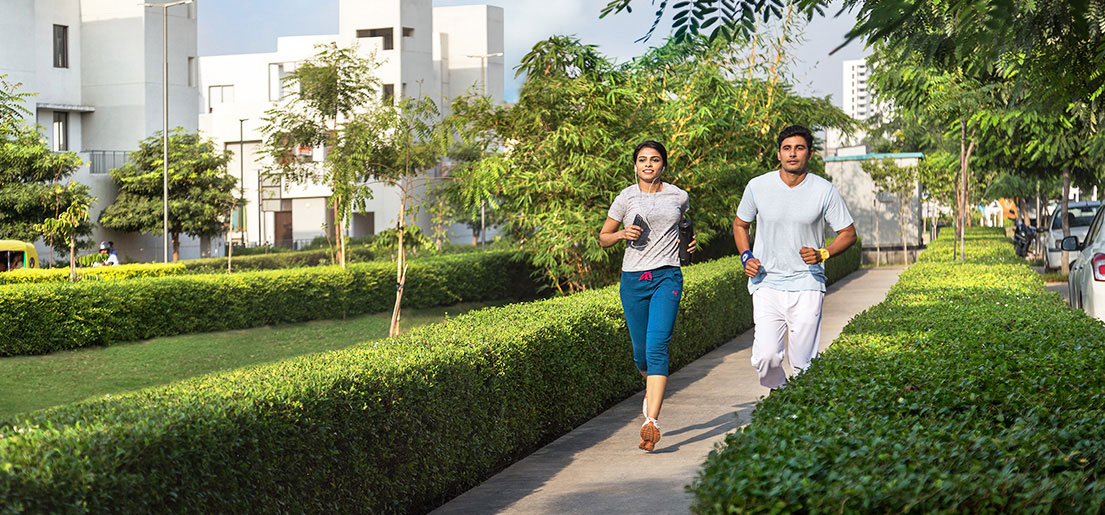 man and woman jogging on walkways in a gated community in vatika india next by vatika group