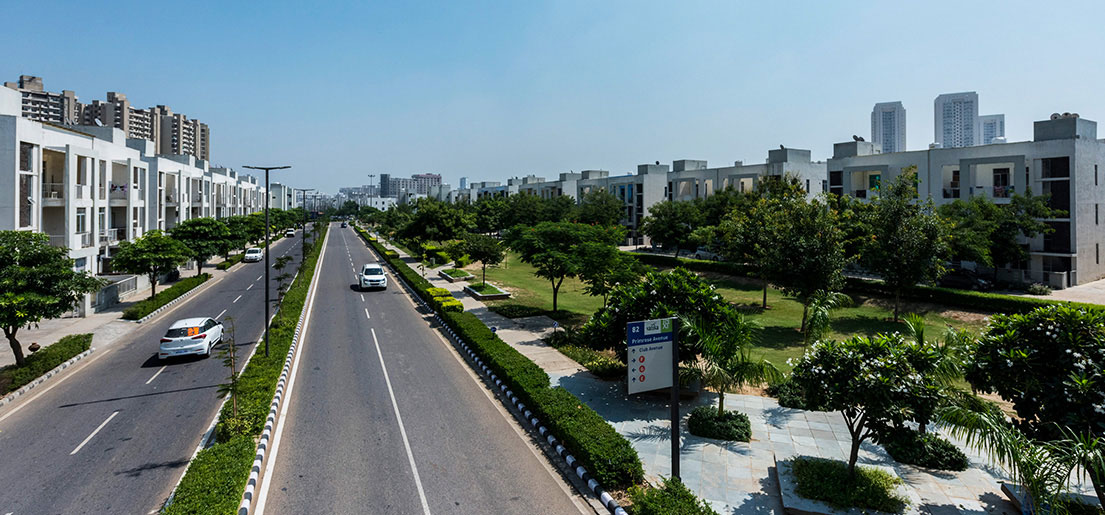 cars driving on the road alongside independent builder floors in vatika india next by vatika group
