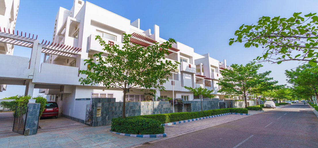 front side view of signature villa and walkways on the side of road in vatika india next by vatika group